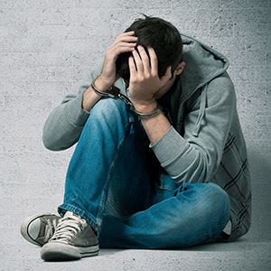 Teenager in handcuffs, representing a juvenile criminal defense lawyer.