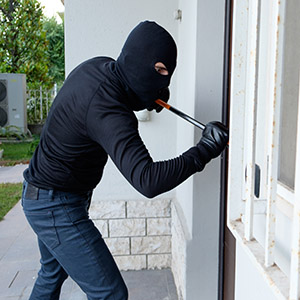 Burglar breaking into a home - A Theft Charge Can Rob You Of Your Future.