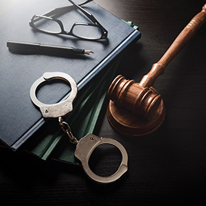 Still life of handcuffs, gavel, and glasses on books - Criminal Law