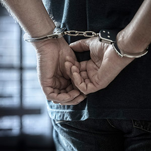 Juvenile with hands cuffed behind their back: Defense For Juveniles Accused Of Criminal Trespass And Mischief.