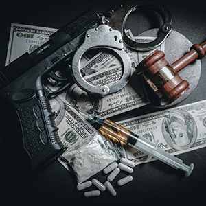 Drug charges still life with handgun, handcuffs, and illegal drugs.