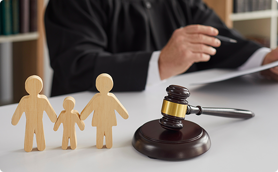 Judge, family figurines, and gavel on a desk, Represent Juvenile Defense Lawyer.