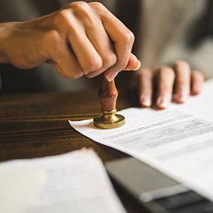 Man with a stamper over a document. Title: Sealing A Juvenile Records.
