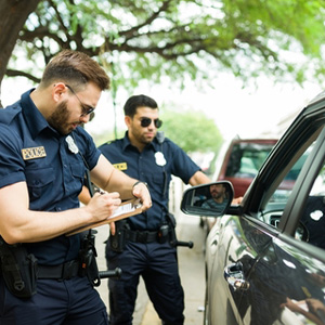 Police officer writing ticket during car stop in Texas; warrant search question.